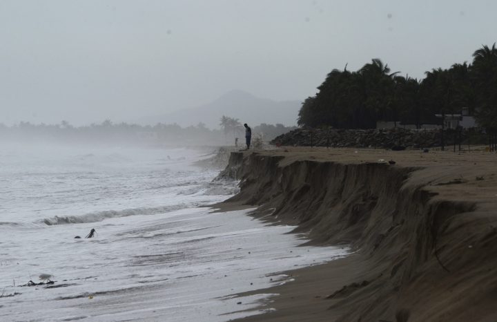 A man looks out at the Pacific ocean after heavy waves caused by approaching Hurricane Max took away part of the beach in Pie de La Cuesta, on the outskirts of Acapulco, Guerrero state, Thursday, Sept. 14, 2017. 