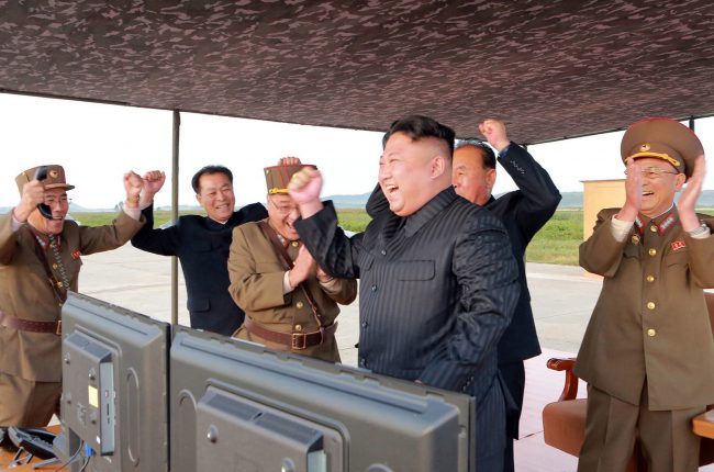 North Korean leader Kim Jong Un celebrates what the North said to be the test launch of an intermediate range Hwasong-12 missile at an undisclosed location, in this undated photo distributed on Sept. 16, 2017.