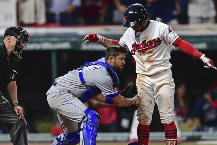 Kansas City Royals catcher Drew Butera, center, tags out Cleveland Indians Francisco Lindor, right, in the ninth inning of a baseball game, Friday, Sept. 15, 2017, in Cleveland.