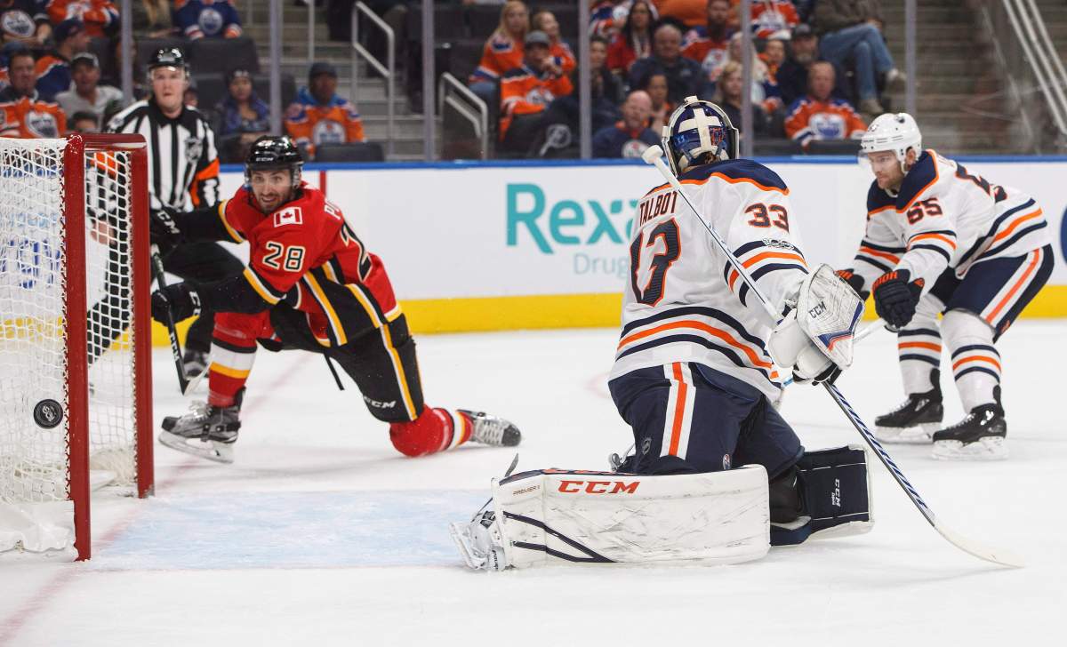 Calgary Flames forward Emile Poirier (28) misses the net as Edmonton Oilers goalie Cam Talbot (33) tries to make the save and forward Mark Letestu (55) back checks during first period NHL preseason split-squad hockey action in Edmonton, Alta., on Monday September 18, 2017.