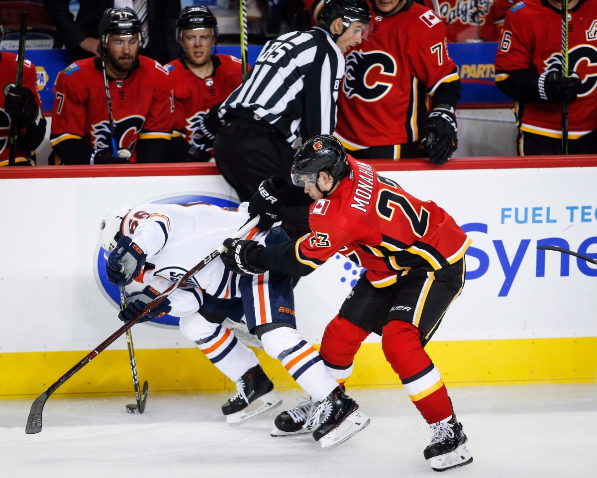 Edmonton Oilers forward Kailer Yamamoto, left, is checked by Calgary Flames forward Sean Monahan during second period NHL preseason split-squad hockey action in Calgary, Monday, Sept. 18, 2017. 