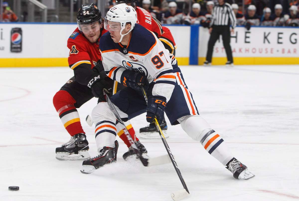 Calgary Flames defenceman Rasmus Andersson (54) battles for the puck with Edmonton Oilers forward Connor McDavid (97) during second period NHL preseason action in Edmonton, Alta., on Monday September 18, 2017.