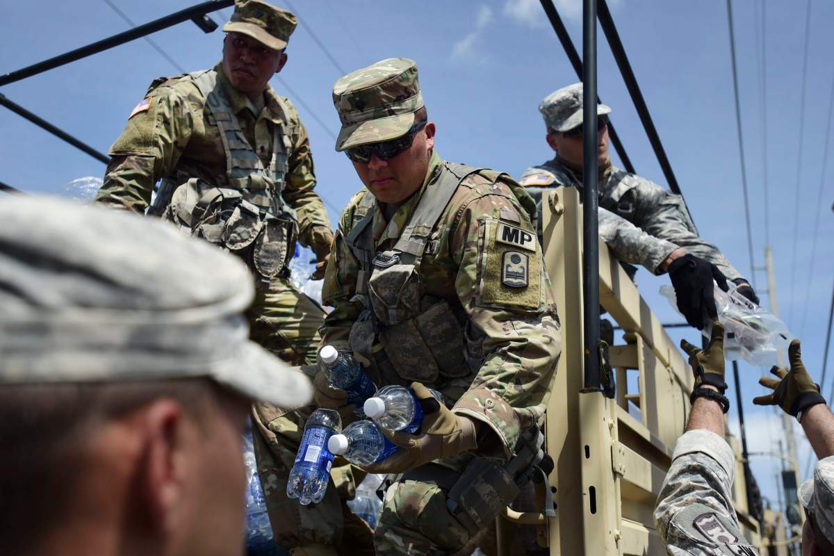 National Guardsmen arrive at Barrio Obrero in Santurce to distribute water and food among those affected by the passage of Hurricane Maria, in San Juan, Puerto Rico, Sunday, Sept. 24, 2017.