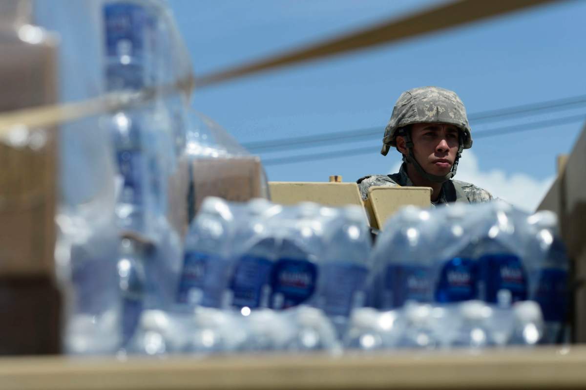 National Guardsmen arrive at Barrio Obrero in Santurce to distribute water and food among those affected by the passage of Hurricane Maria, in San Juan, Puerto Rico, Sunday, Sept. 24, 2017.