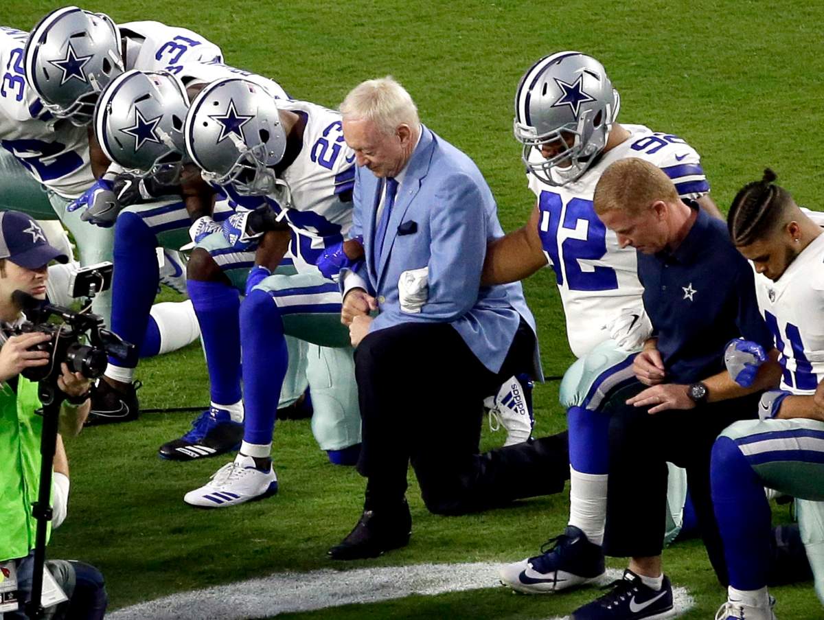 The Dallas Cowboys, led by owner Jerry Jones, centre, take a knee prior to the national anthem prior to an NFL football game against the Arizona Cardinals, Monday.