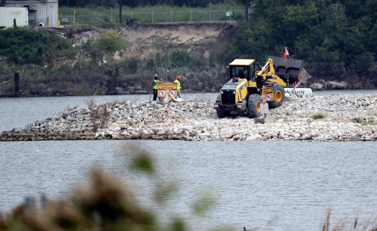 In this Sept. 13, 2017 photo, workers are shown at San Jacinto River Waste Pits near the Interstate 10 bridge over the river in Channelview, Texas.  