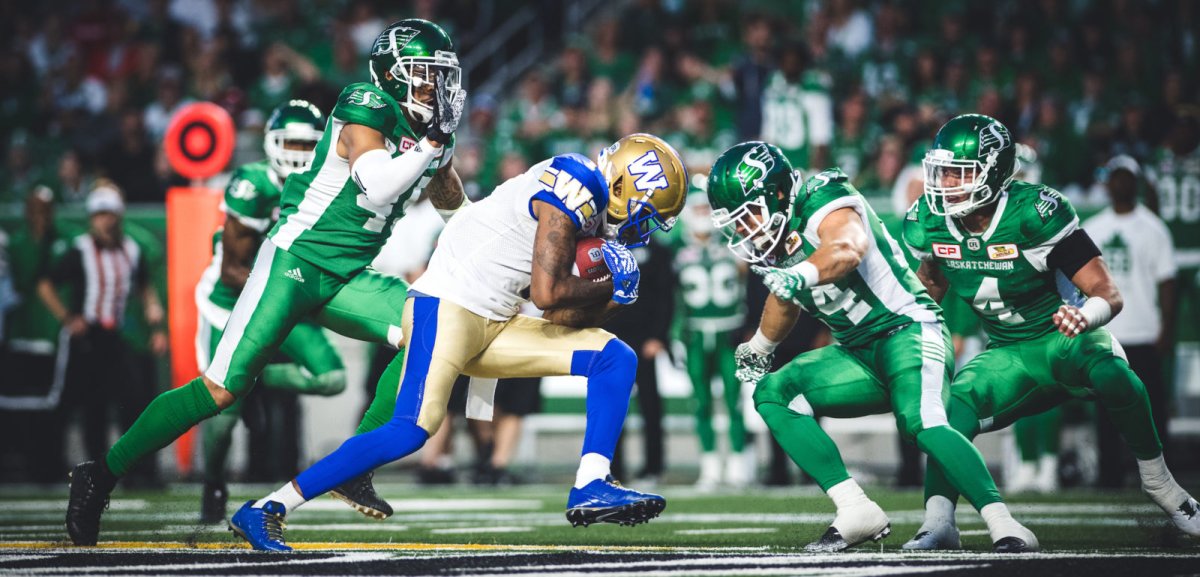 Darvin Adams (1) of the Winnipeg Blue Bombers and Kacy Rodgers II (45) and Jeff Hecht (24) of the Saskatchewan Roughriders during the game at New Mosaic Stadium in Regina, SK, Saturday, July 1st, 2017. (Photo: Johany Jutras).
