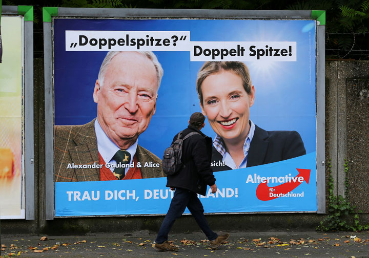 A man looks at at a placard of Alexander Gauland and Alice Weidel, the top candidates of Germany's anti-immigration party Alternative fuer Deutschland (AfD) ahead of the September 24 German federal election.