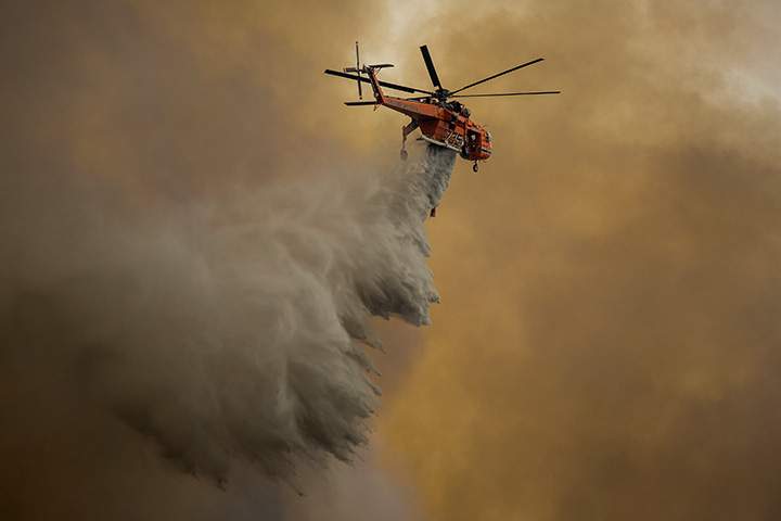 An Erickson Air Crane firefighting helicopter drops water over the La Tuna Fire on September 2, 2017 near Burbank, California.