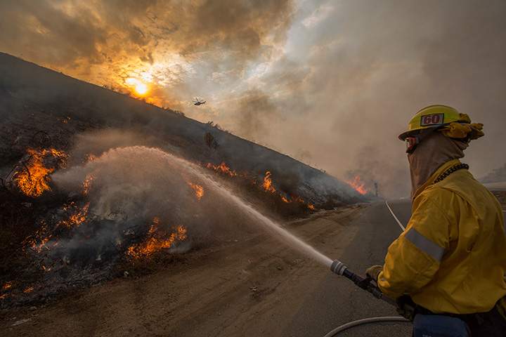 Firefighters use hoses and helicopters to fight the La Tuna Fire on September 2, 2017 near Burbank, California.