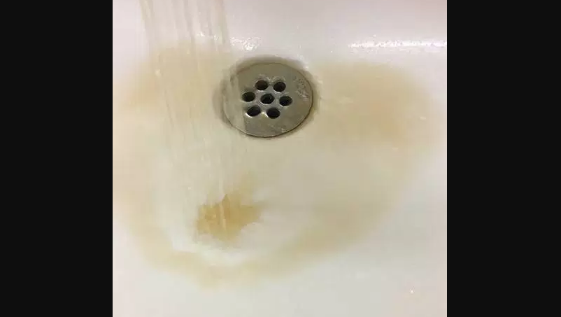 Brown water runs out of a tap at Mobile Central High School in Mobile, N.L., in this Wednesday, Sept. 6, 2017 handout photo. Students at Mobile Central High School in Mobile, N.L., are drinking bottled water over concerns that their high school's well is too close to an adjacent graveyard.