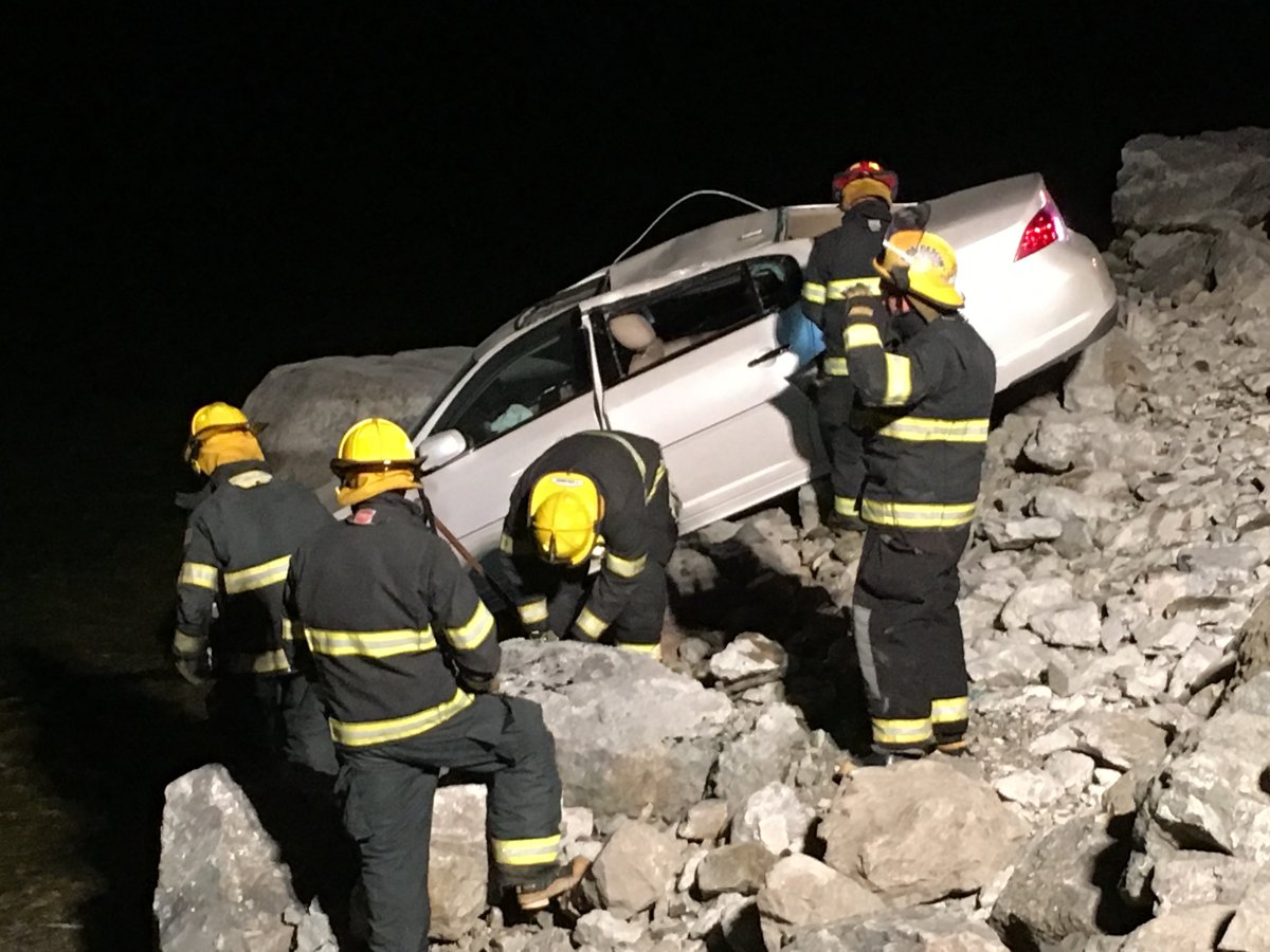 Peachland fire crews look to assist removing a vehicle that crashed off Highway 97 at Okanagan Lake Tuesday night. 
