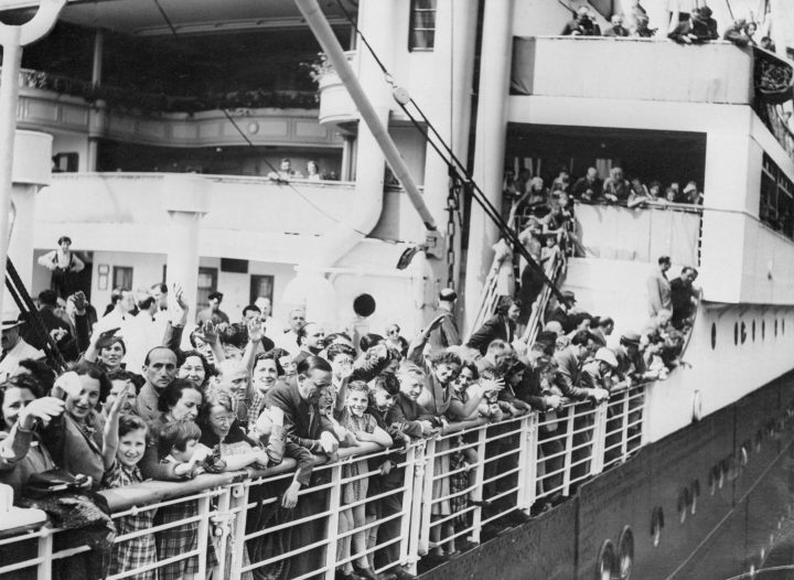 A crowd of German-Jewish refugees aboard the MS St. Louis ocean liner wave as they arrive in Antwerp, Belgium, after wandering the Atlantic for thousands of miles. 