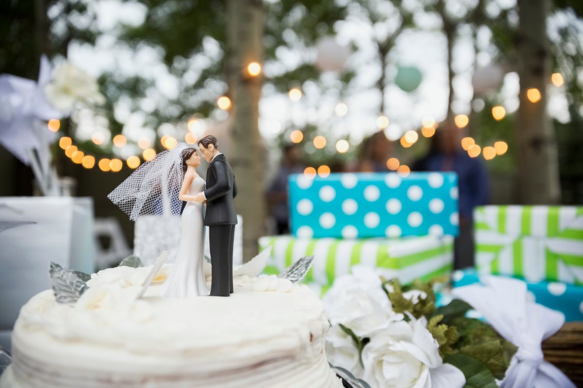 Bride and groom cake topper on cake.