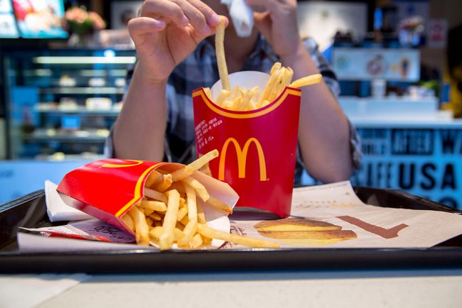 A girl eats fries in a McDonald's restaurant. 

