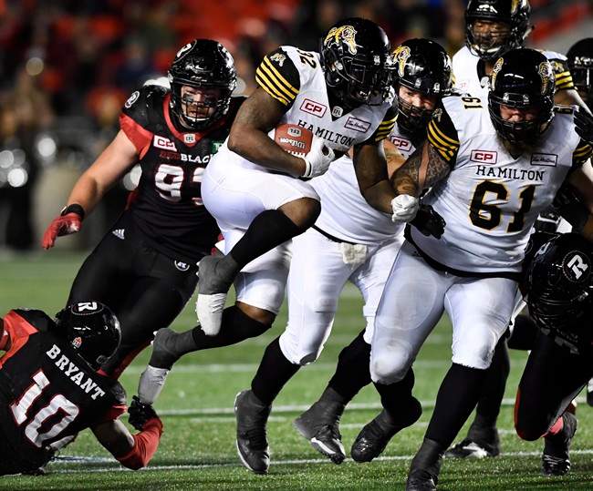 Hamilton Tiger-Cats' C.J. Gable (32) leaps past Ottawa Redblacks' Sederius Bryant (10) as he runs with the ball during second half CFL football action against the Ottawa Redblacks, in Ottawa on Saturday, Sept. 9, 2017.