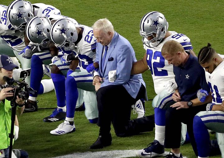 The Dallas Cowboys, led by owner Jerry Jones, center, take a knee prior to the national anthem prior to an NFL football game against the Arizona Cardinals, Monday, Sept. 25, 2017, in Glendale, Ariz. 