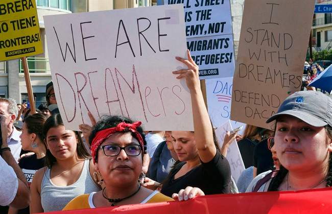 Supporters of the Deferred Action for Childhood Arrivals, or DACA chant slogans and hold signs while joining a Labor Day rally in downtown Los Angeles on Monday, Sept. 4, 2017. President Donald Trump is expected to announce this week that he will end the Deferred Action for Childhood Arrivals, but with a six-month delay, according to two people familiar with the decision-making. (AP Photo/Richard Vogel).