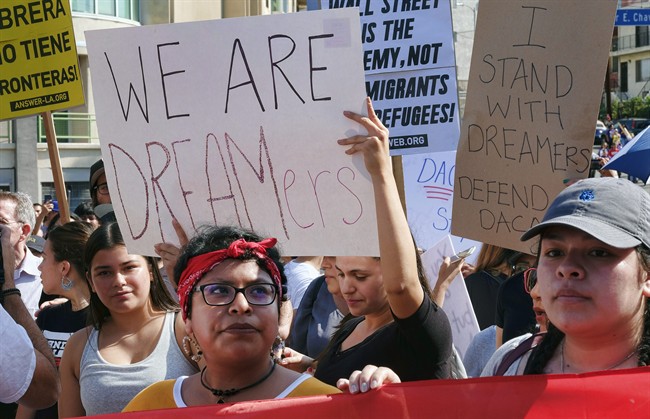 Supporters of the Deferred Action for Childhood Arrivals, or DACA chant slogans and hold signs while joining a Labor Day rally in downtown Los Angeles on Monday, Sept. 4, 2017. President Donald Trump is expected to announce this week that he will end the Deferred Action for Childhood Arrivals, but with a six-month delay, according to two people familiar with the decision-making. (AP Photo/Richard Vogel).