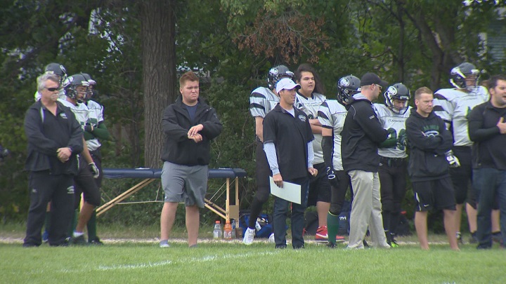 Coaches and players on the Murdoch MacKay Clansmen watch from the sidelines during a game in 2014.