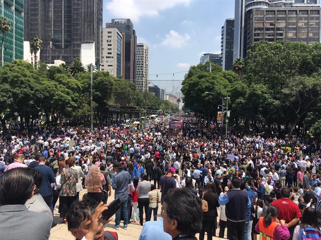 People fill Paseo de la Reforma after evacuating from their offices after an earthquake in Mexico City, Tuesday, Sept. 19, 2017.