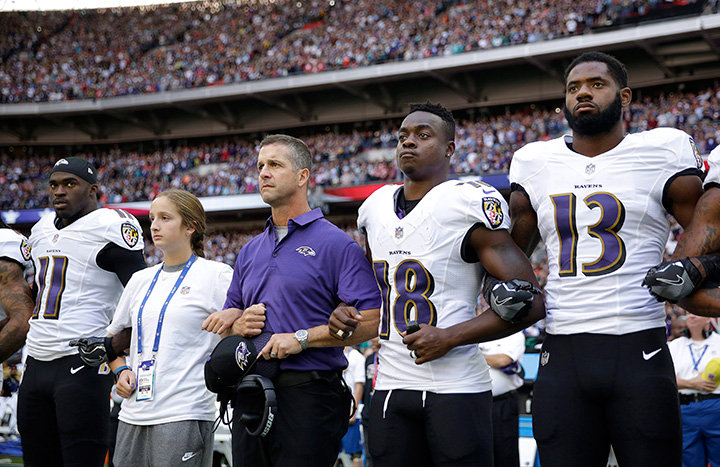 Baltimore Ravens head coach John Harbaugh, centre left, links arms with his daughter Alison and wide receiver Jeremy Maclin during the playing of the U.S. national anthem before their game against the Jacksonville Jaguars at Wembley Stadium in London, Sunday Sept. 24, 2017.