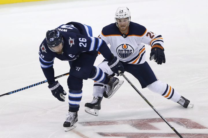Winnipeg Jets' Blake Wheeler (26) and Edmonton Oilers' Brad Malone (24) collide during third period NHL pre-season game action in Winnipeg on Wednesday, September 20, 2017. 