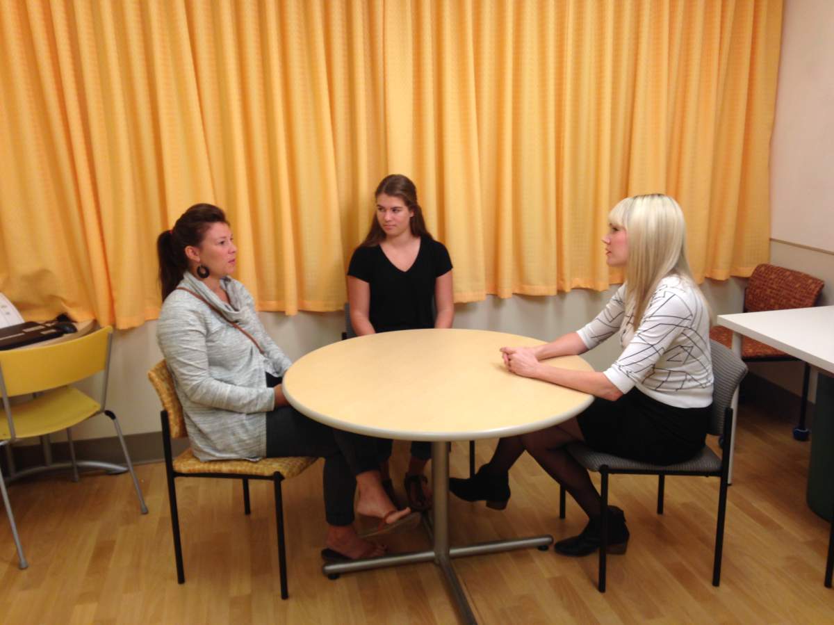 Hannah Cripps, a 16-year-old  chronic pain sufferer sits with her mother at psychology researcher Melanie Noel at the Alberta Children's Hospital.