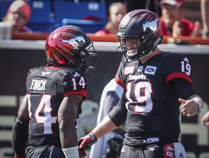 Calgary Stampeders' Roy Finch, left, celebrates his touchdown with quarterback Bo Levi Mitchell during first half CFL football action against the Edmonton Eskimos in Calgary, Monday, Sept. 4, 2017.