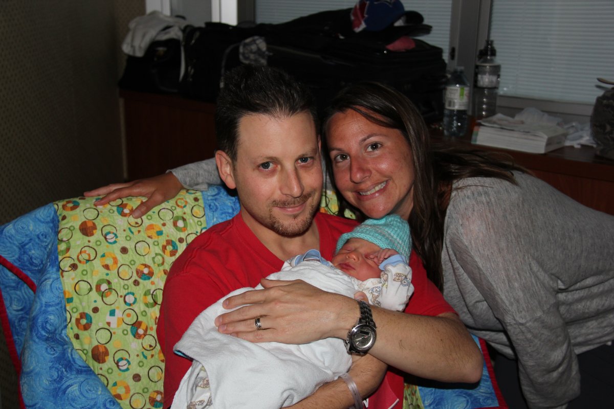 Melanie Parnass and her husband, Noah Katz, cradle their newborn son.