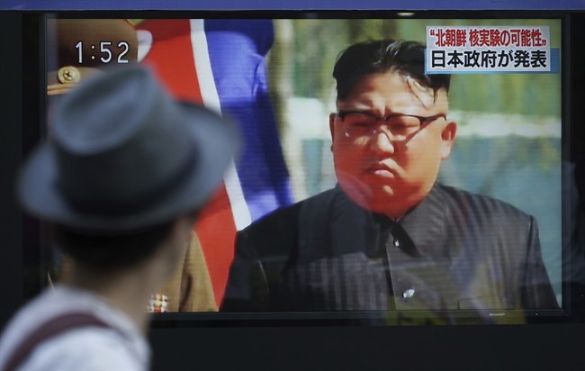 FILE - In this Sept. 3, 2017, file photo, a man in Tokyo watches a TV news program on a public screen showing an image of North Korean leader Kim Jong Un while reporting North Korea's possible nuclear test.