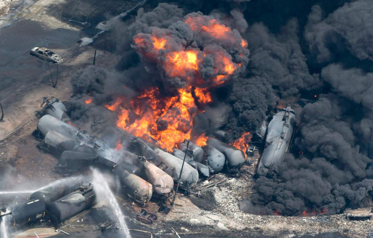 Smoke rises from railway cars that were carrying crude oil after derailing in downtown Lac-Mégantic, Que., Saturday, July 6, 2013. 