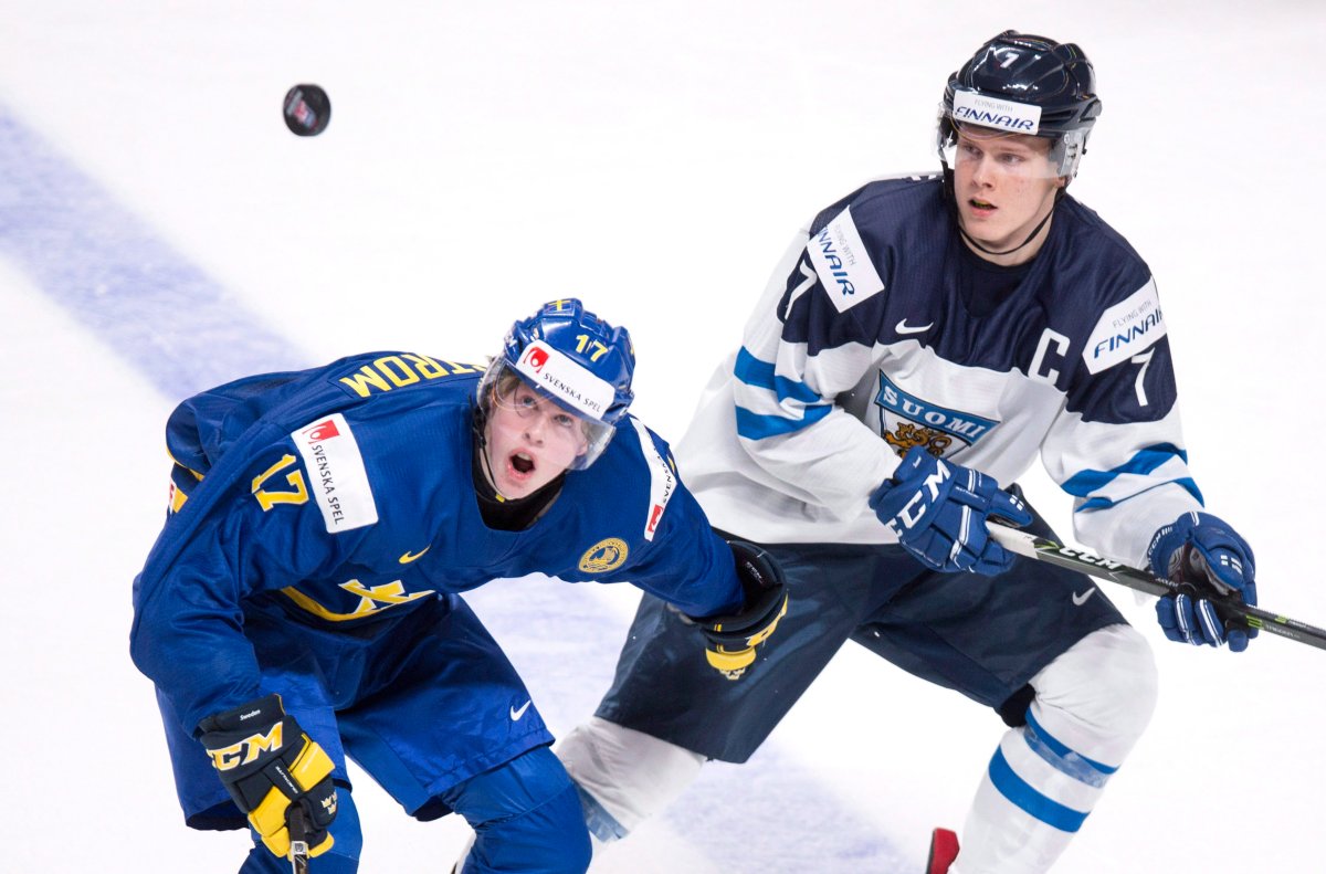 Sweden's Fredrik Karlstrom, left, and Finland's Olli Juolevi keep their eyes on the puck during first period IIHF World Junior Championship hockey action Thursday, December 29, 2016 in Montreal. THE CANADIAN PRESS/Paul Chiasson.