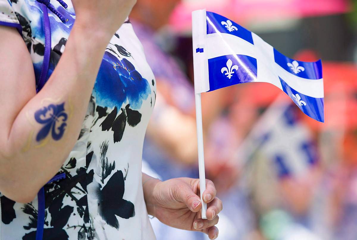 A woman holds a Quebec flag.