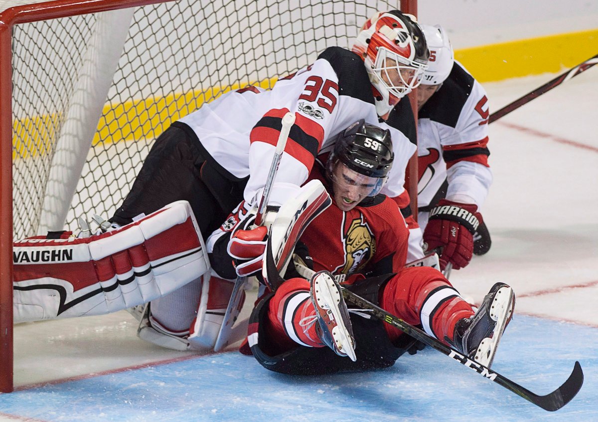 Ottawa Senators Alex Formenton is knocked into New Jersey Devils goaltender Cory Schneider during second period NHL preseason hockey action in Summerside, P.E.I., on Monday, Sept. 25, 2017. THE CANADIAN PRESS/Andrew Vaughan.
