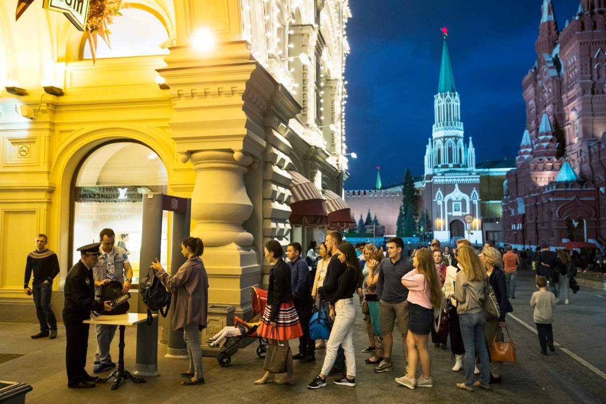FILE - In this Wednesday, Sept. 13, 2017 file photo, people are checked by security guards before entering GUM, State Shop, at Red square in Moscow, Russia. Moscow is grappling with a slew of fake bomb calls that have prompted the evacuation of shopping malls, schools, railway stations and administrative buildings.  (AP Photo/Pavel Golovkin, file).