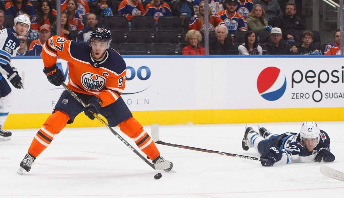 Winnipeg Jets' Nikolaj Ehlers (27) reaches for Edmonton Oilers' Connor McDavid (7) during second period NHL action in Edmonton, Alta., on Monday, October 9, 2017. 