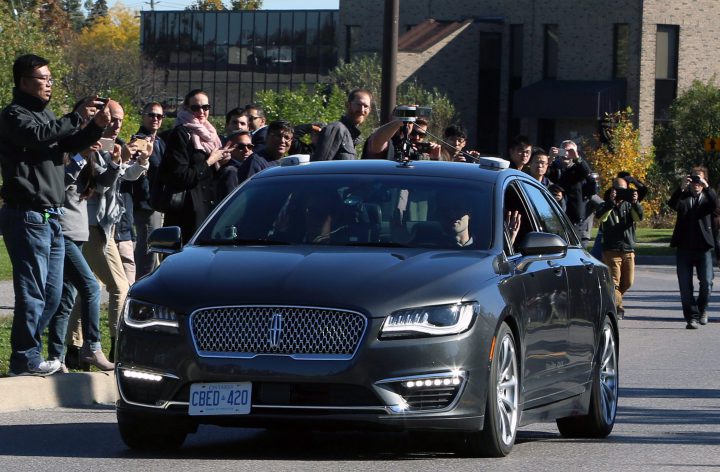 People watch as an autonomous car drives down an Ottawa street as the City of Ottawa and Blackberry QNX demonstrate the vehicle on Oct. 12.