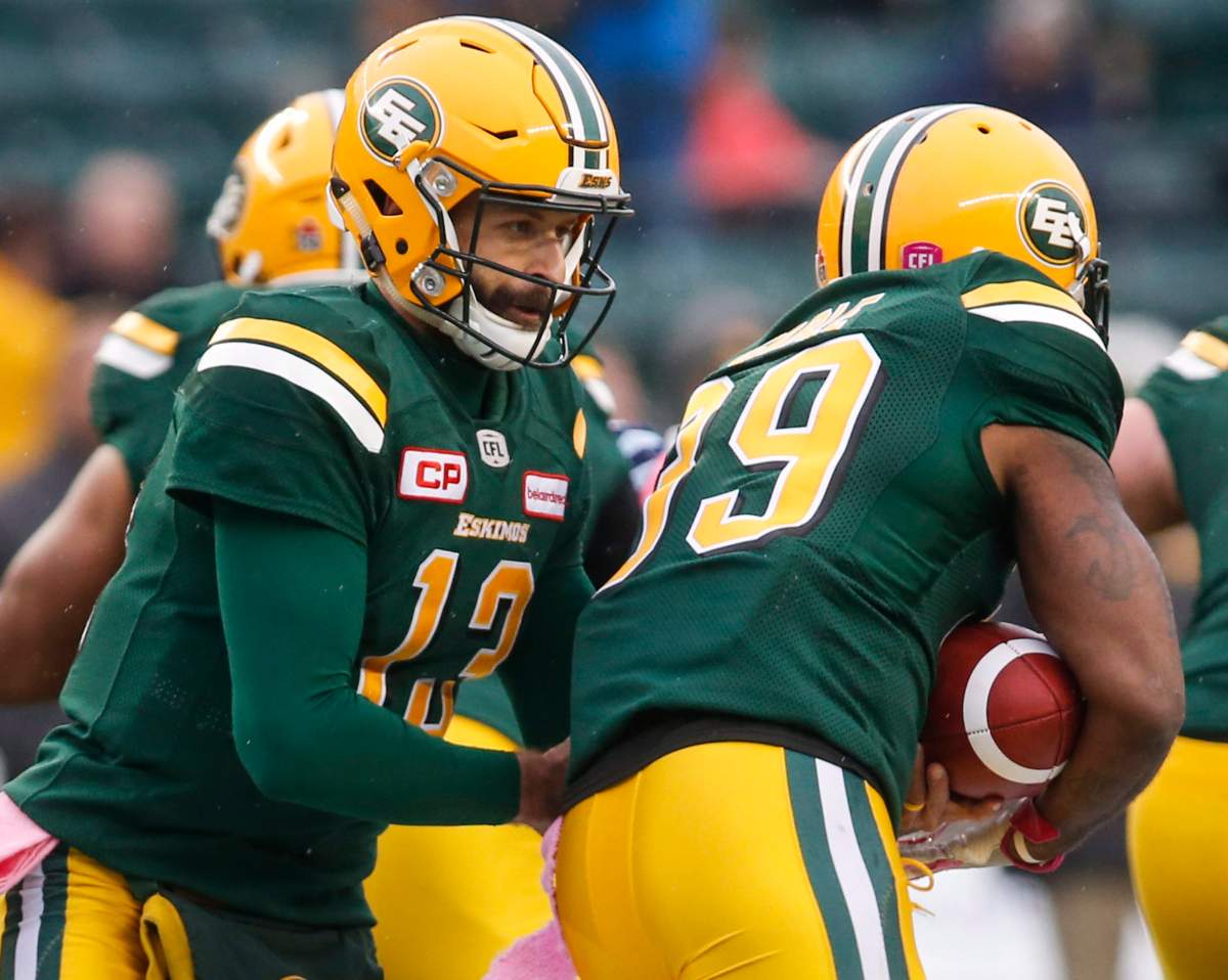 Edmonton Eskimos quarterback Mike Reilly, left, hands the ball off to teammate C.J. Gable during first half CFL football action against the Toronto Argonauts, in Edmonton, Saturday, Oct. 14, 2017. 