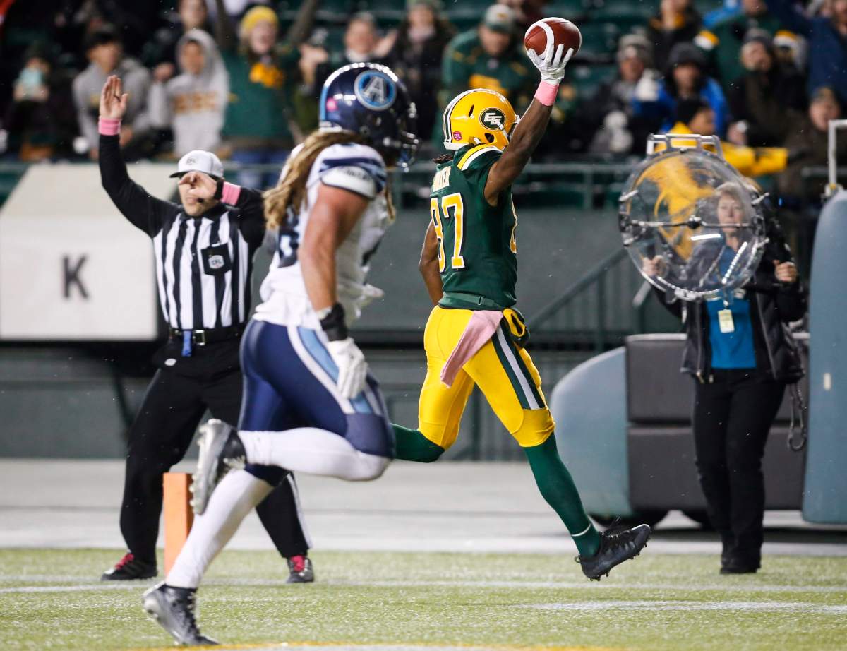 Toronto Argonauts' Bear Woods, left, looks on as Edmonton Eskimos' Derel Walker celebrates his game-winning touchdown during second half CFL football action in Edmonton, Saturday, Oct. 14, 2017. 