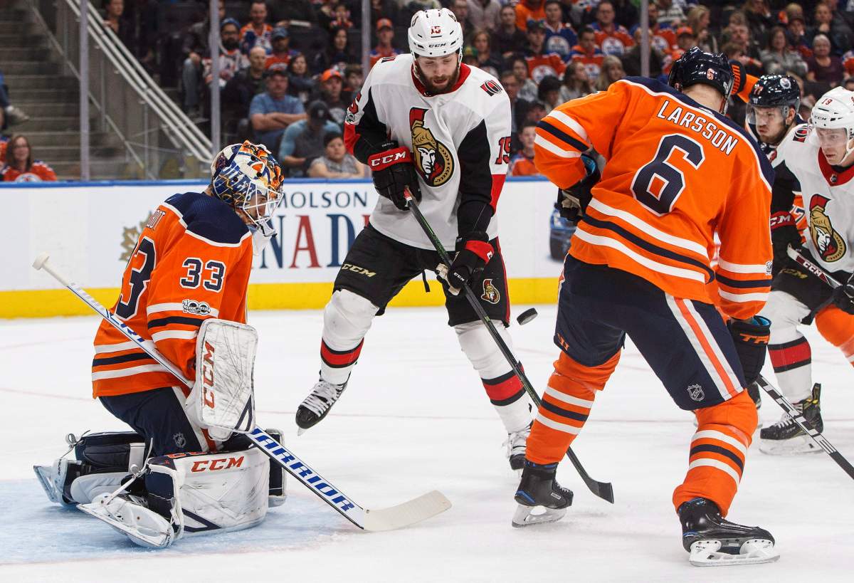 Ottawa Senators' Zack Smith (15) tries to tip the puck past Edmonton Oilers goalie Cam Talbot (33) as Adam Larsson (6) defends during first period NHL hockey action in Edmonton on Oct. 14, 2017.