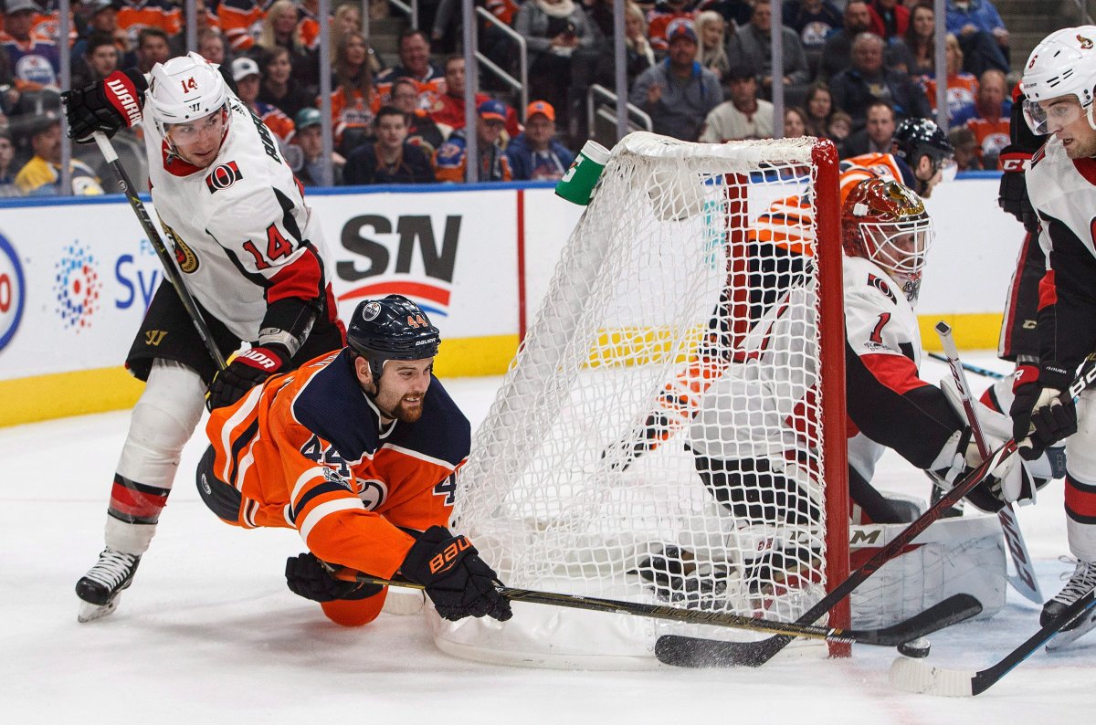 Ottawa Senators' Alex Burrows (14) hooks Edmonton Oilers' Zack Kassian (44) as he tries to put the puck past goalie Mike Condon (1) during second period NHL action in Edmonton on Saturday, October 14, 2017.