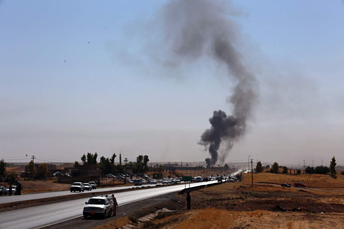 Smoke rises while Iraqi security forces use bombs as Kurdish security forces withdraw from a checkpoint in Alton Kupri, outskirts of Irbil, Iraq, Friday Oct. 20, 2017.  A Baghdad court issued an arrest warrant for the vice president of Iraq's autonomous northern Kurdish region on Thursday for saying that Iraqi forces had "occupied" the disputed province of Kirkuk this week.