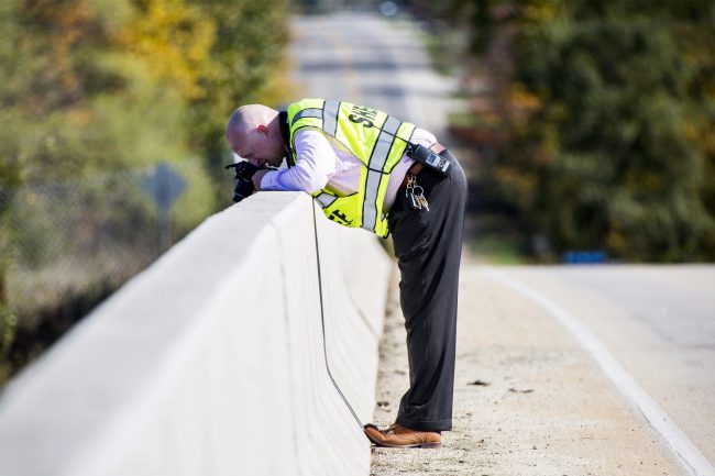 A Genesee County Sheriff's Office investigator takes photos from an overpass where Dodge Road crosses Interstate 75 near the scene of a traffic fatality Friday, Oct. 20, 2017, in Vienna Township, Mich. 


