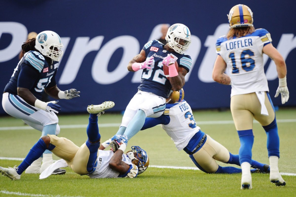 Toronto Argonauts running back James Wilder Jr. (32) scores a touchdown as Winnipeg Blue Bombers defensive back TJ Heath (23) and defensive back Kevin Fogg (3) try to stop him during first half CFL football action in Toronto on Saturday, October 21, 2017. THE CANADIAN PRESS/Nathan Denette.