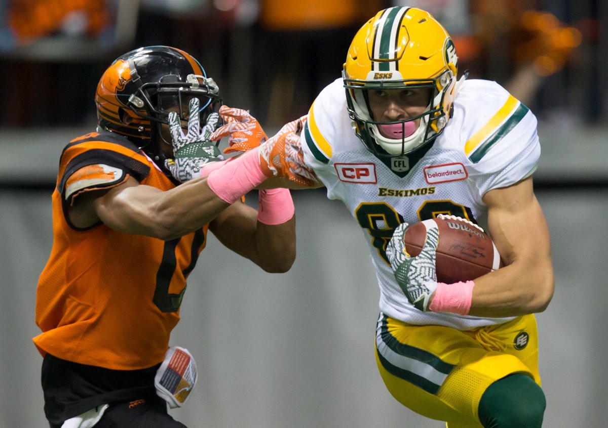 Edmonton Eskimos' Brandon Zylstra, right, fights off B.C. Lions' Loucheiz Purifoy during the first half of a CFL football game in Vancouver, B.C., on Saturday October 21, 2017.