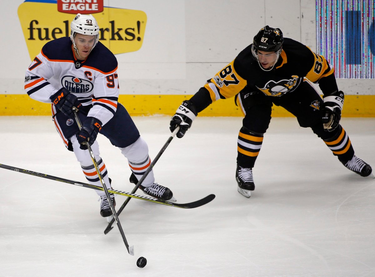 Edmonton Oilers' Connor McDavid (97) and Pittsburgh Penguins' Sidney Crosby (87) battle for a loose puck in the first period of an NHL hockey game in Pittsburgh, Tuesday, Oct. 24, 2017. (AP Photo/Gene J. Puskar).