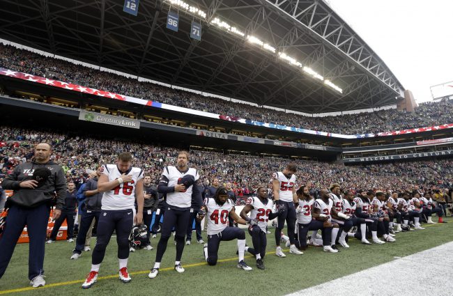Houston Texans players kneel and stand during the singing of the national anthem before an NFL football game against the Seattle Seahawks, Oct. 29, 2017, in Seattle.