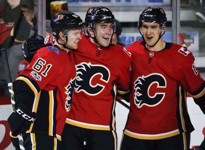 Calgary Flames left wing Micheal Ferland (79) celebrates his goal with defenceman Brett Kulak (61) and centre Mikael Backlund (11) from Sweden, during second period NHL hockey action against the Washington Capitals in Calgary, Sunday, Oct. 29, 2017. 