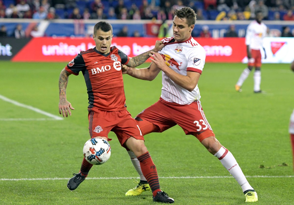 Toronto FC forward Sebastian Giovinco, left, holds off New York Red Bulls midfielder Aaron Long (33) during the second half of an MLS Eastern Conference semifinal soccer match Monday, Oct. 30, 2017, in Harrison, N.J. Toronto FC won 2-1. 